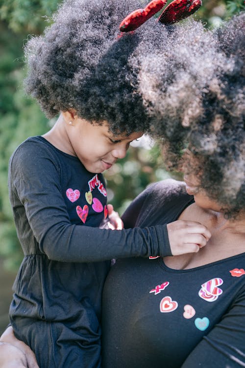 A Child Placing Stickers on her Mom