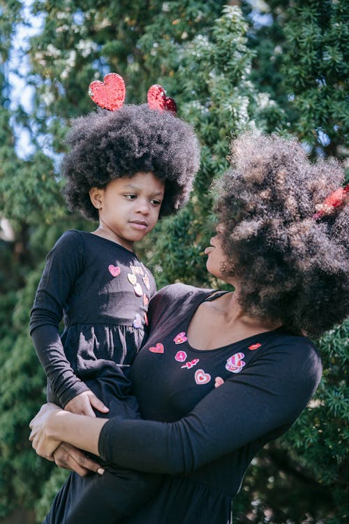 Free A Woman Carrying her Daughter at a Park Stock Photo