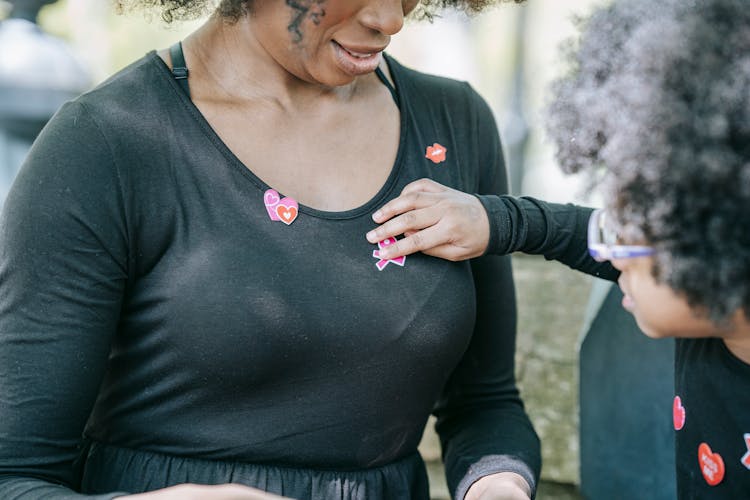 A Child Placing Stickers On Her Mom