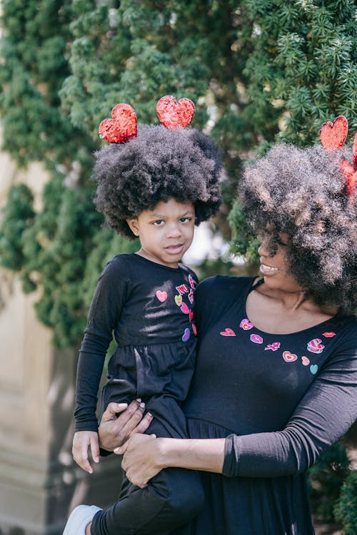 Free A Woman Carrying her Daughter at a Park Stock Photo