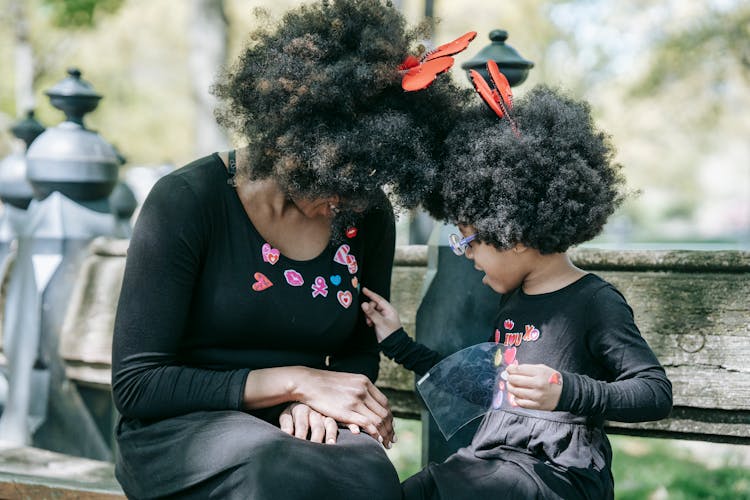 A Child Placing Stickers On Her Mom