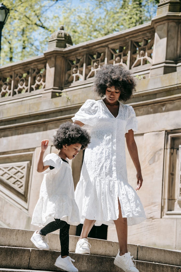 A Woman And A Girl Walking Down The Steps