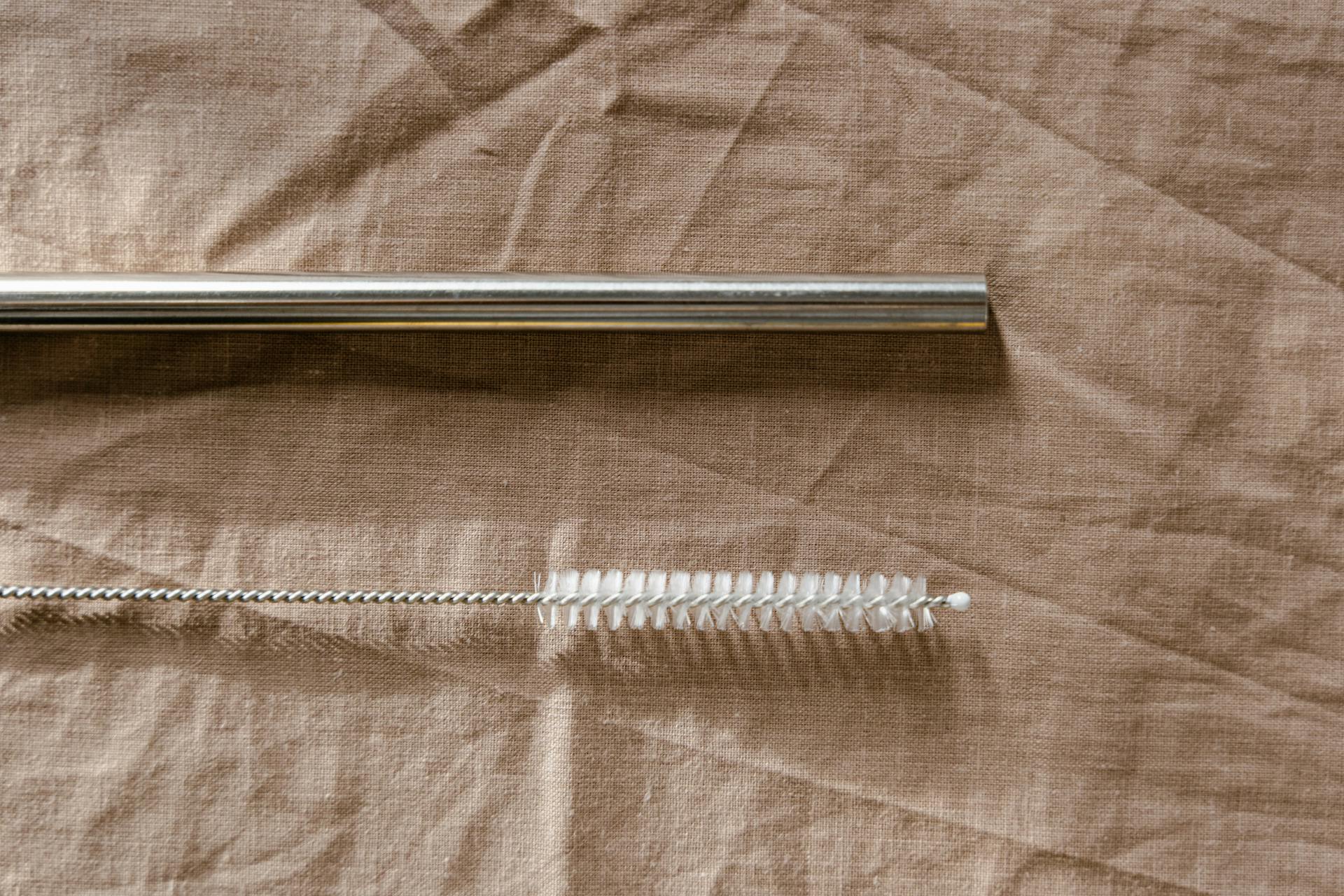 Close-up of a Metal Straw and a Cleaning Brush