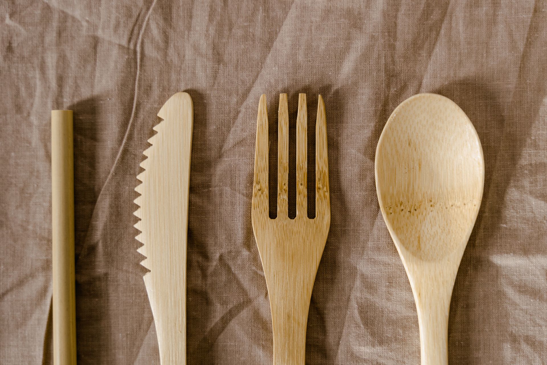 Reusable bamboo cutlery set on linen, promoting sustainable living.