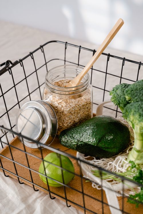 Free Wire basket with avocado, lime, broccoli, and oatmeal in a glass jar. Stock Photo