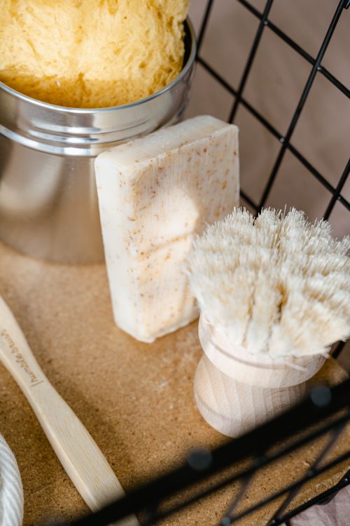 Free Close-up of an eco-friendly bath set featuring natural soap, brush, and metal container. Stock Photo