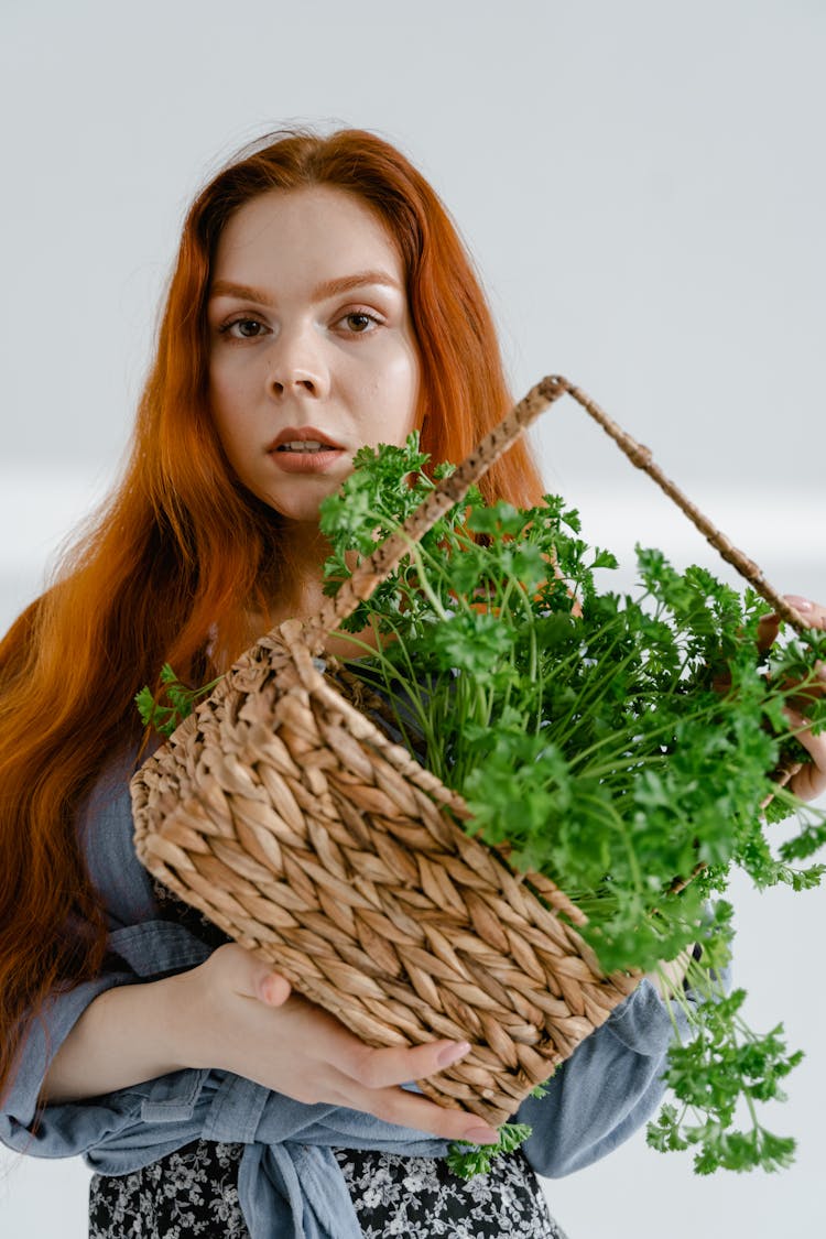 A Young Woman Holding A Basket Of Herbs