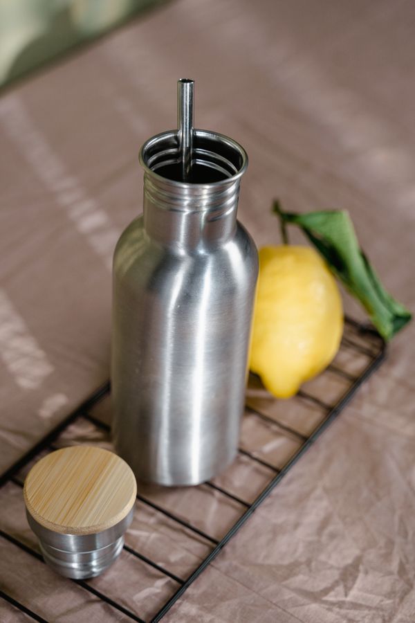 Unbranded steel bottle with a bamboo lid beside a lemon — photo by Tima Miroshnichenko on Pexels