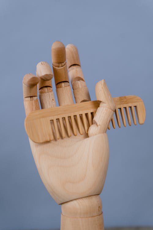 Brown Wooden Comb on Brown Wooden Hand