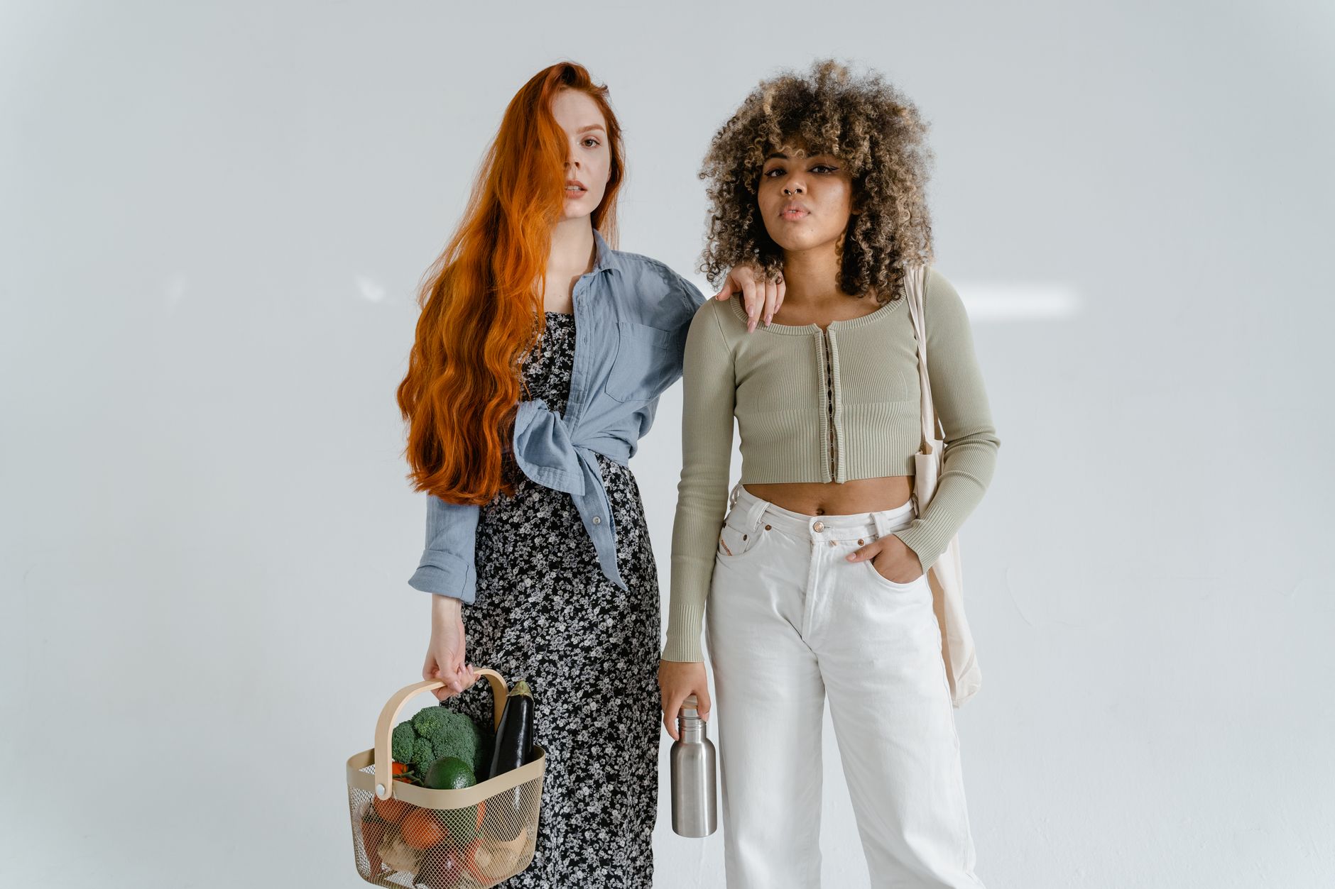 Two fashionable women with grocery items embodying eco-friendly lifestyle.