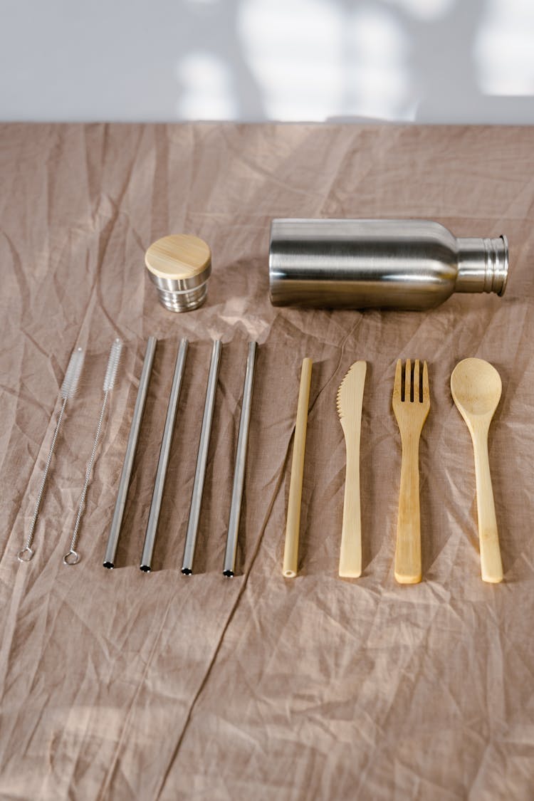 Wooden Utensils And Reusable Drinking Straws On Brown Cloth 