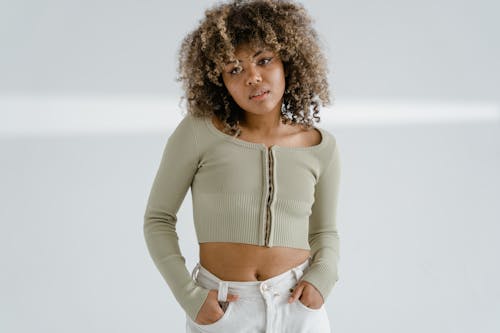 Free A Curly-Haired Woman Wearing a Crop Top Posing Stock Photo