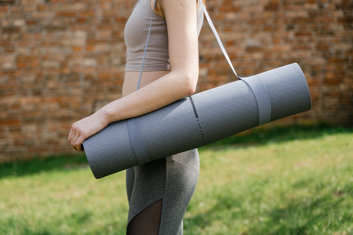 A Person Carrying a Yoga Mat · Free Stock Photo