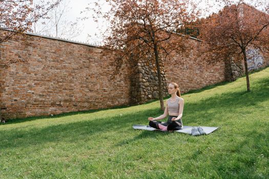 A serene moment of meditation on a grassy field with blooming trees.