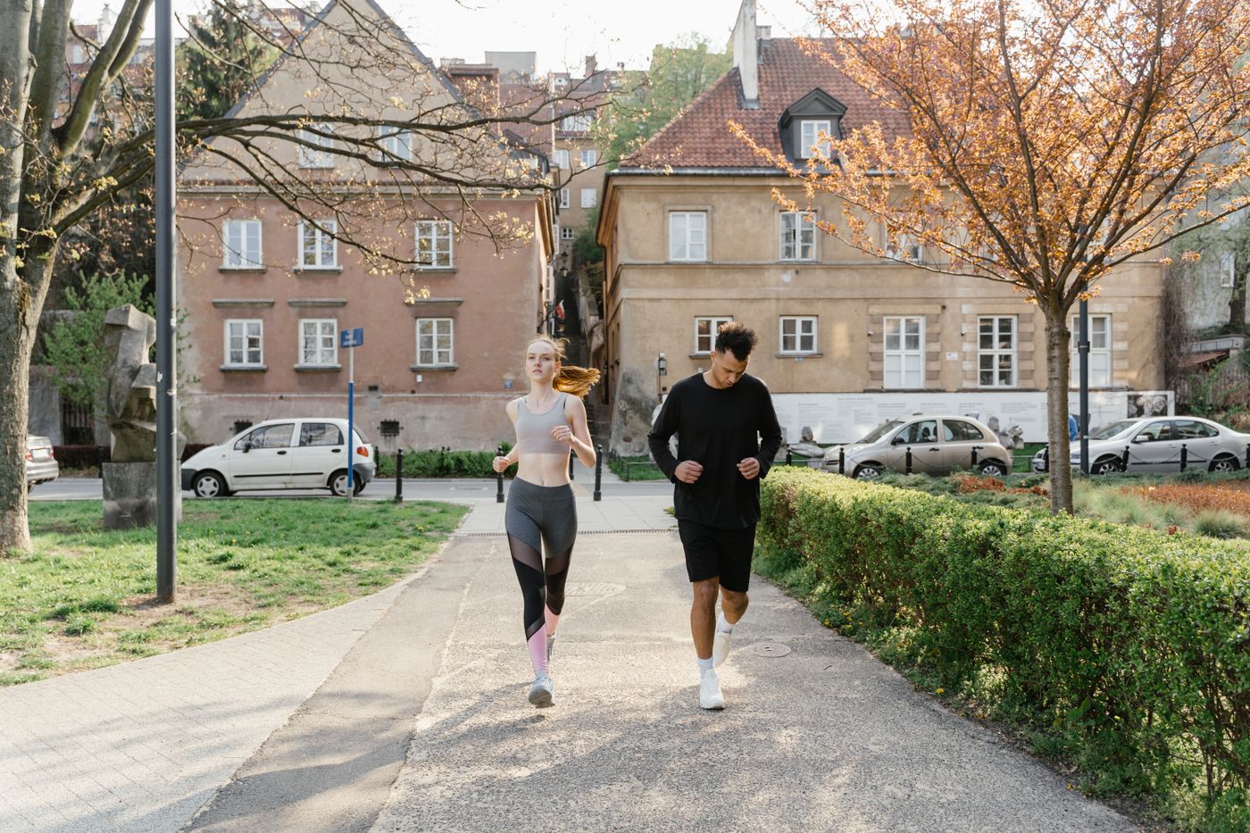 Two adults running together in a park