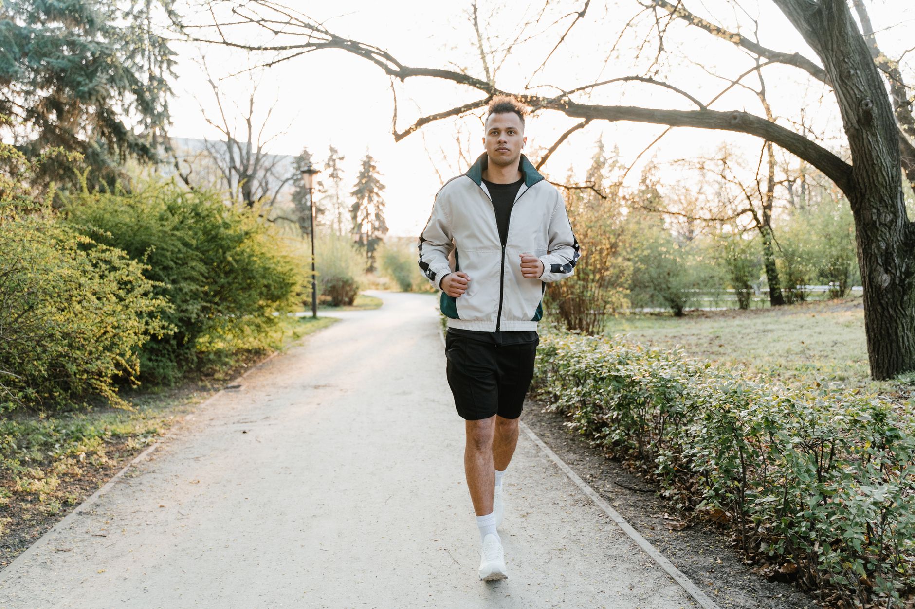 A person walking outdoors on a path in early morning light, the kind of daily action a health coaching program is built around