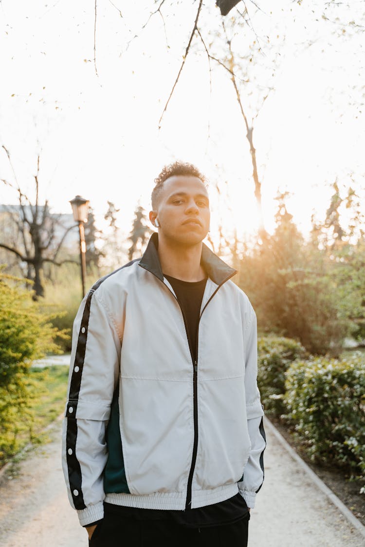 Man In Gray Jacket Standing On Gray Pathway