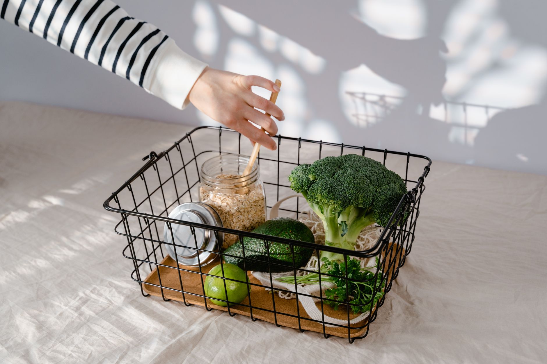 地中海飲食準備技巧:事半功倍的實用指南 A hand reaches into a basket with fresh vegetables and grains, emphasizing healthy choices.