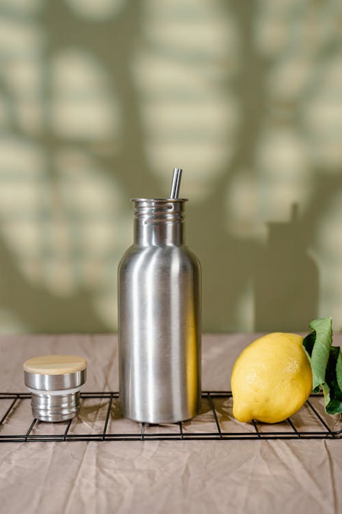 Stainless Steel Vacuum Flask Beside Beside the Yellow Lemon Fruit