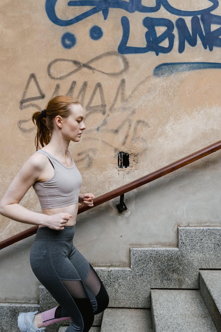 Woman Wearing Sports Bra Running On The Stairs