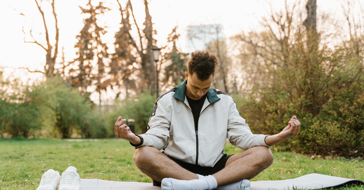 A serene woman practicing yoga in a sunlit room surrounded by plants.