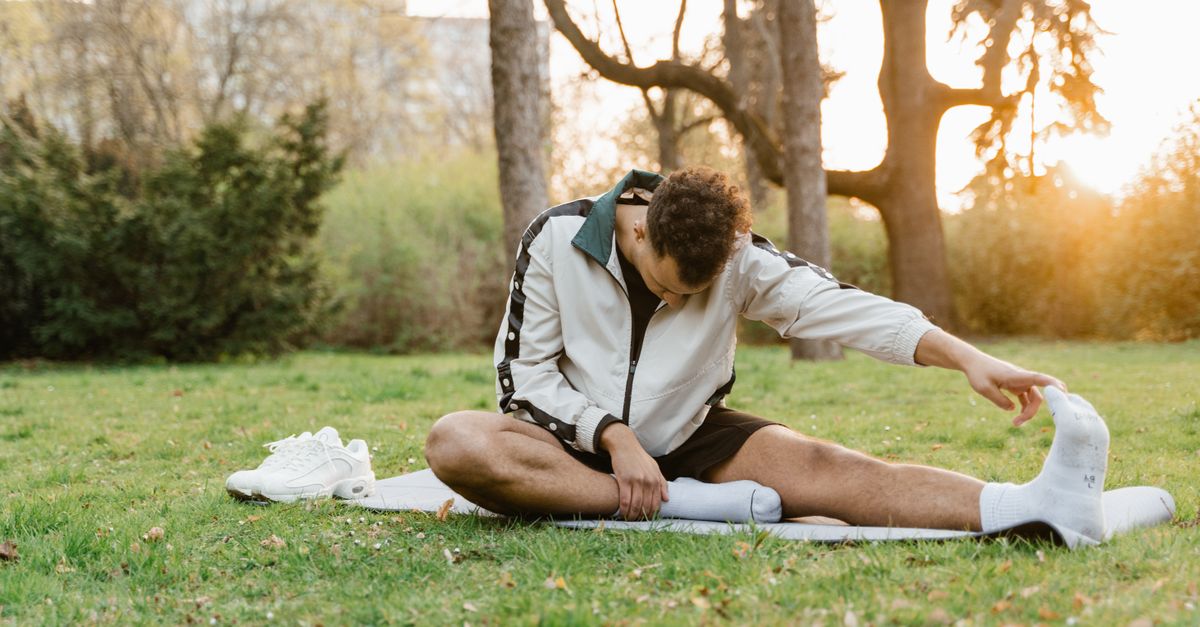 Person stretching at sunrise with a calm expression