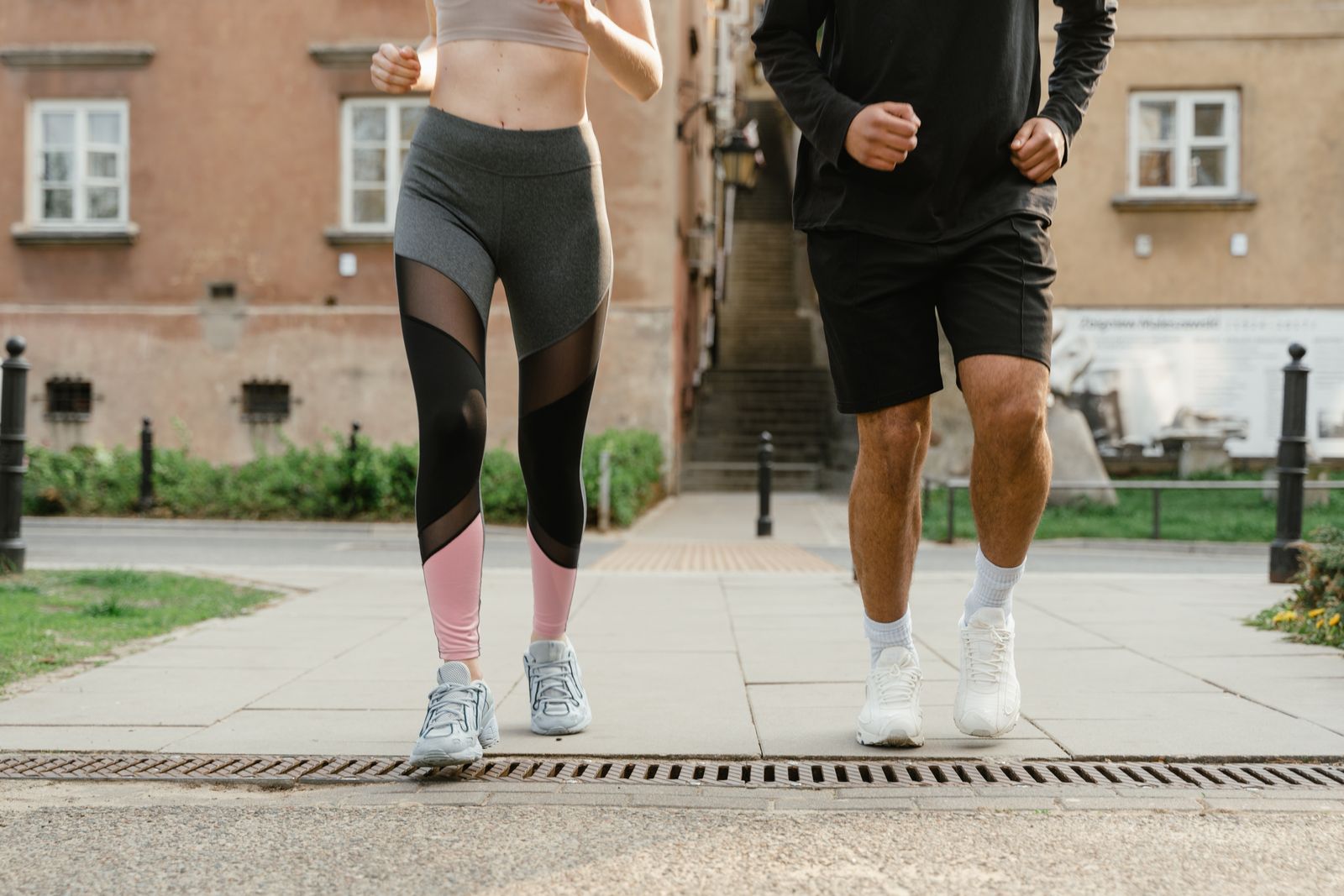 Runner stretching calf muscles outdoors in bright daylight