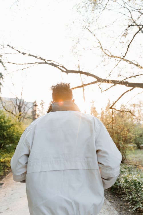 Free Back View of a Man Walking on the Park Stock Photo