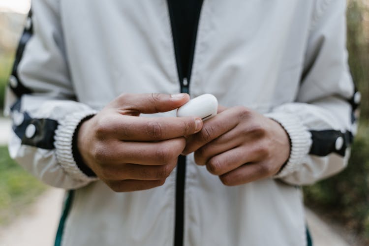 Close-up Photo Of Person Holding Earpods