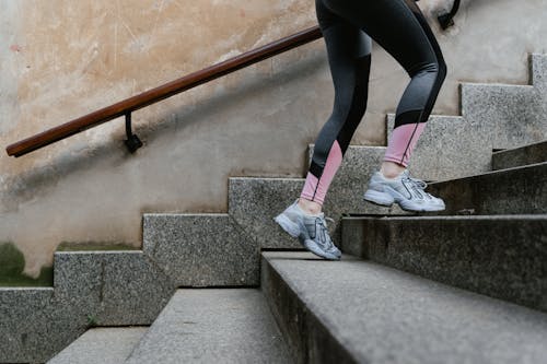 Free Person in Active Wear Going Up Stairs Stock Photo