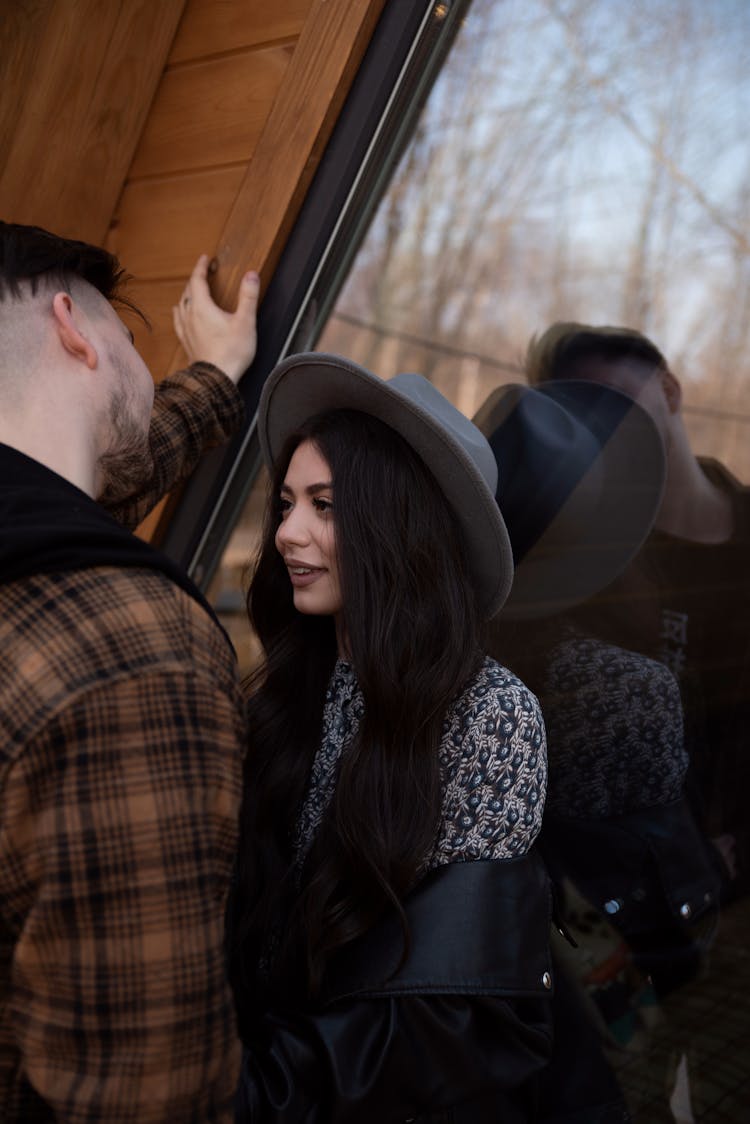 Couple Standing Near House Window In Countryside