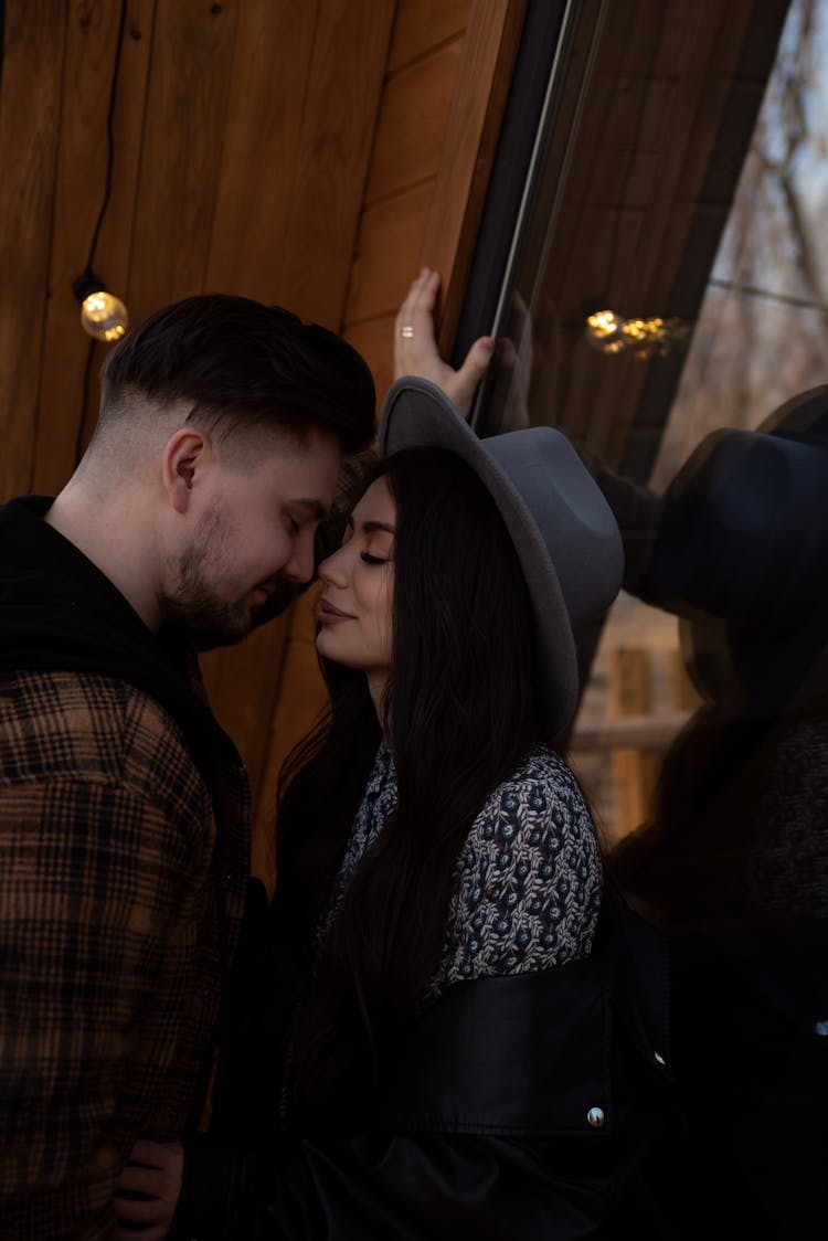 Couple Standing Near Building Window With Closed Eyes