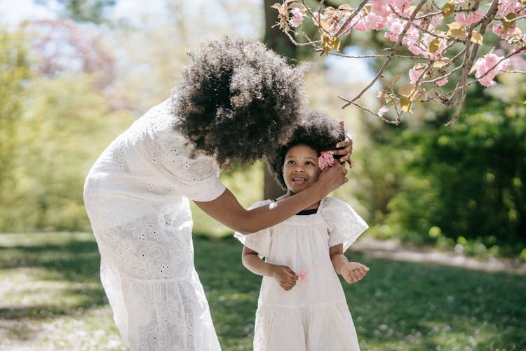 Mother Putting Flower On Her Daughter's Ear