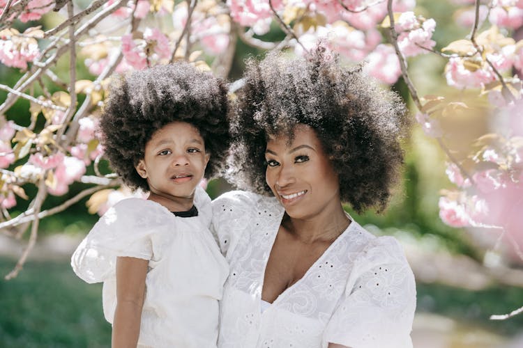 Mother And Daughter Smiling And Looking At Camera