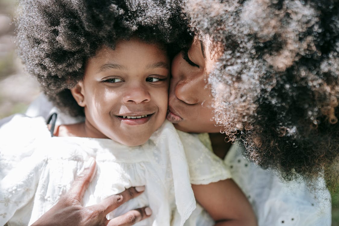 Free A Woman Kissing a Young Girl Stock Photo