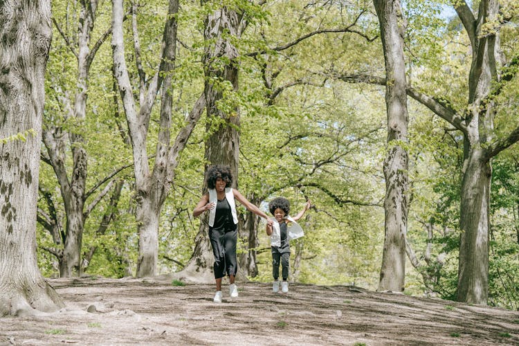 Mother And Child Running Hand In Hand In The Park