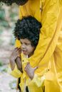 Woman in Yellow Coat Holding Her Chin