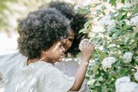 Woman in White Shirt Holding White Flower