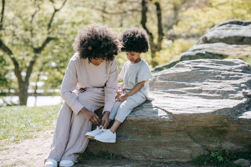 A Woman Tying her Child's Shoelaces