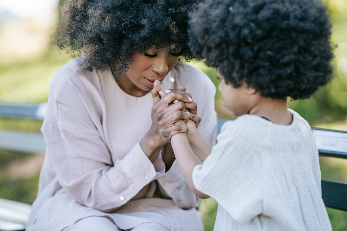 Free A Woman and a Young Girl Praying Together Stock Photo