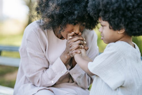 A Woman Kissing her Daughter's Hands