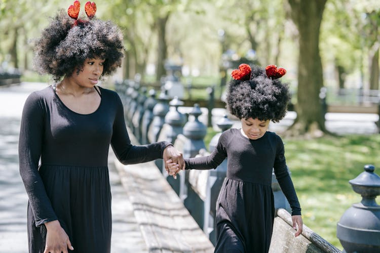 Mother And Daughter Walking In The Park