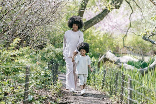 Free A Woman and a Young Girl Holding Hands while Walking  Stock Photo