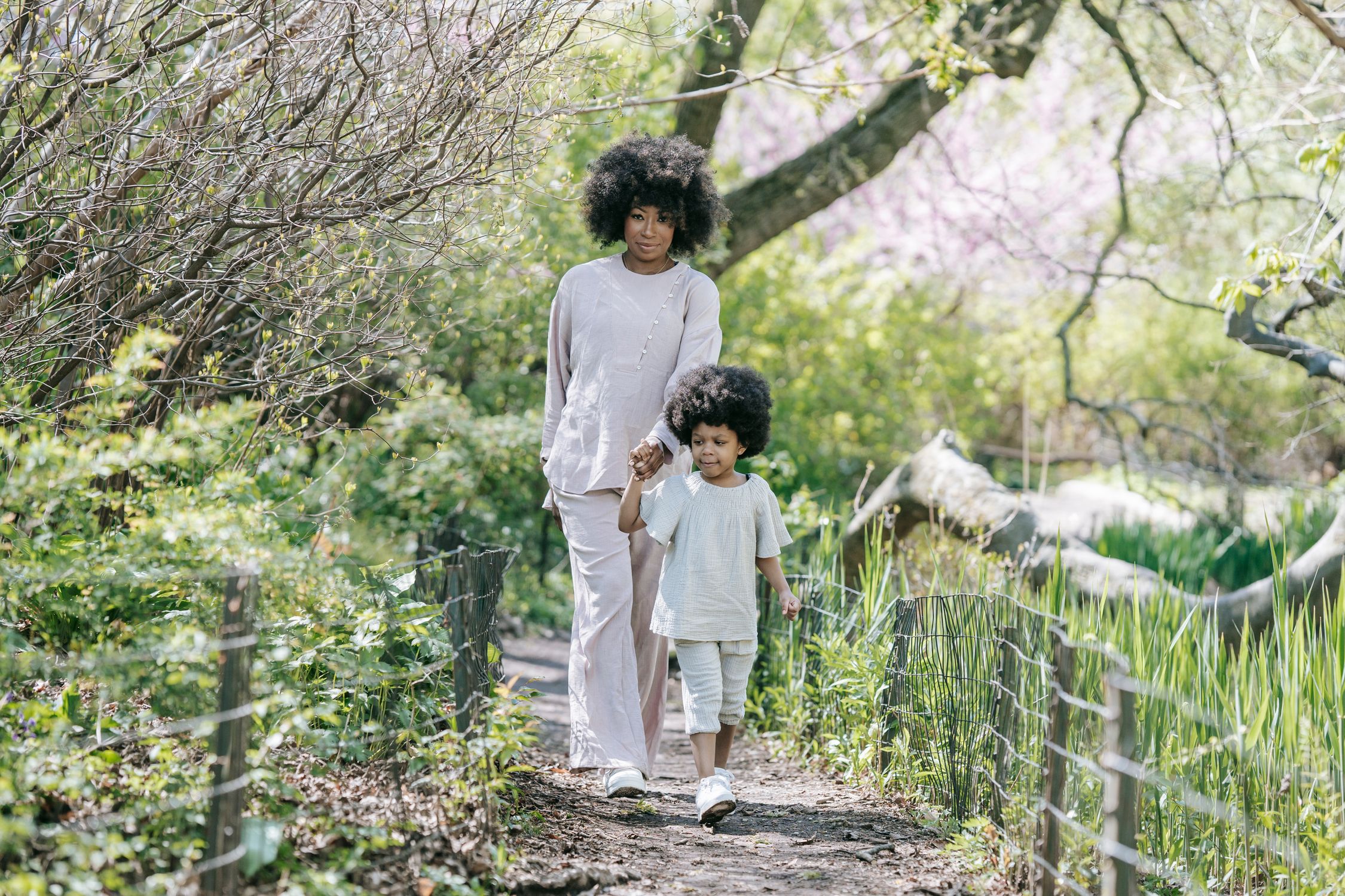 A Woman and a Young Girl Holding Hands while Walking · Free Stock Photo