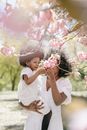 A Woman Carrying her Daughter While Looking at Flowers
