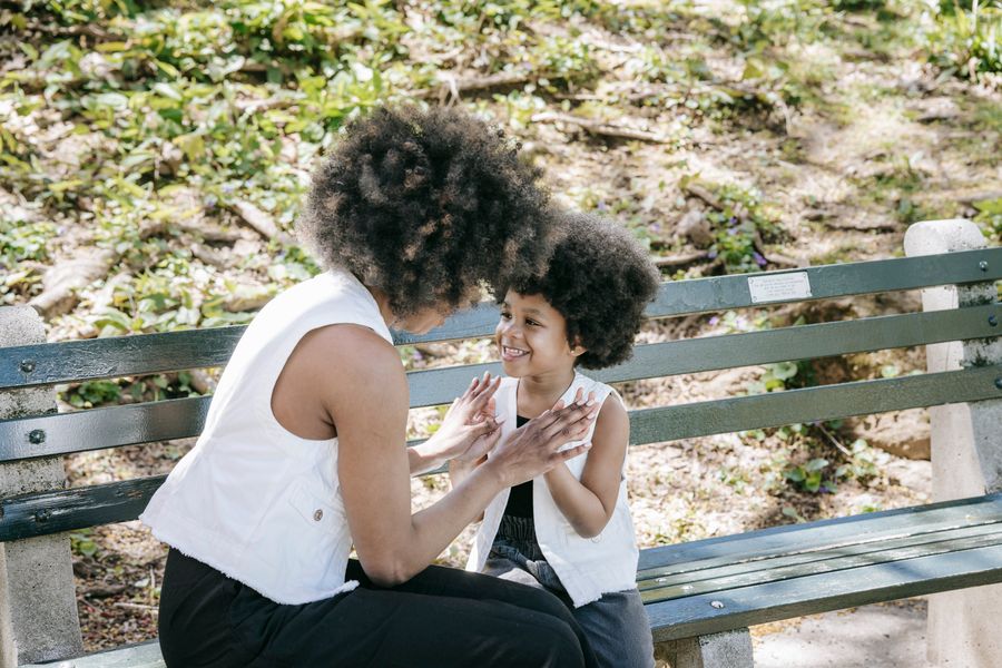 Smiling mother and daughter sharing a happy moment on a bench