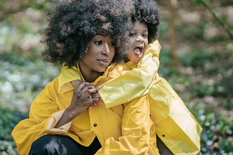 Shallow Focus Of A Mother And Her Daughter Wearing Yellow Raincoat