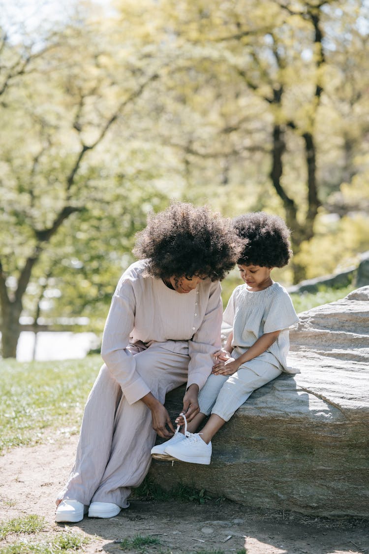 A Woman Tying Her Child's Shoelaces