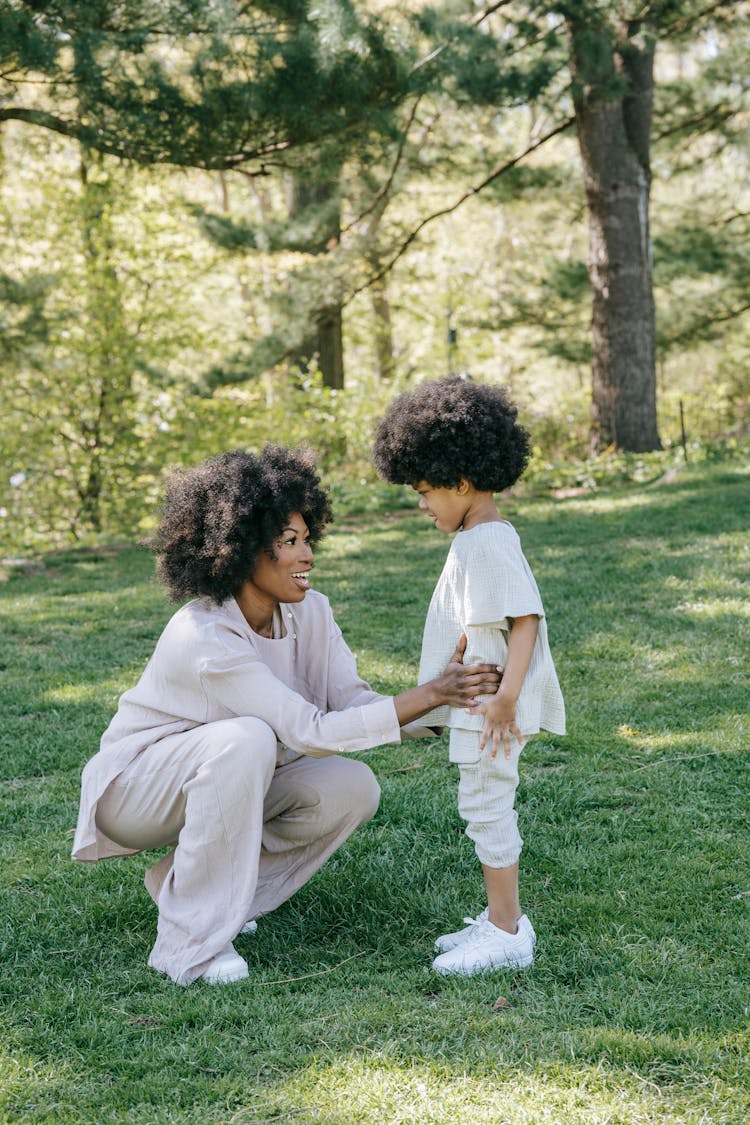 A Woman Talking To Her Child At A Park