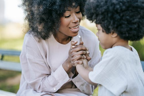 A Woman Holding a Young Girl's Hands